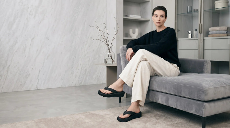 Mulher usando chinelo nuvem ortopédico feminino em ambiente interno moderno e confortável