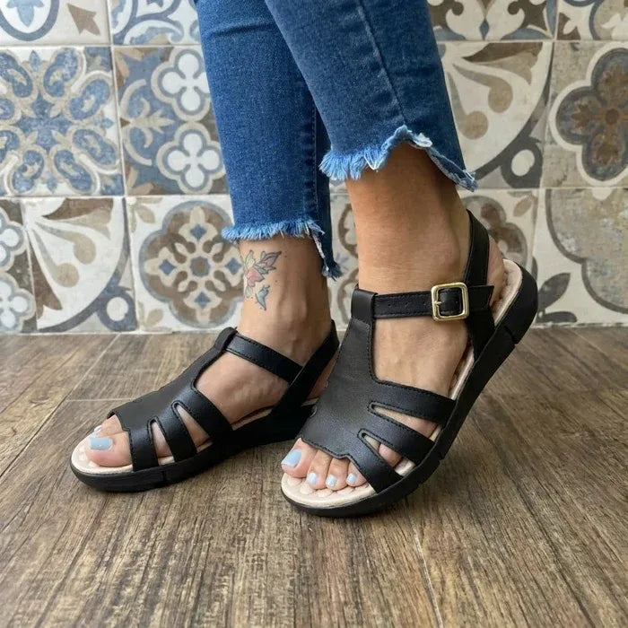Sandália ortopédica feminina Calira™ preta sendo usada com calça jeans