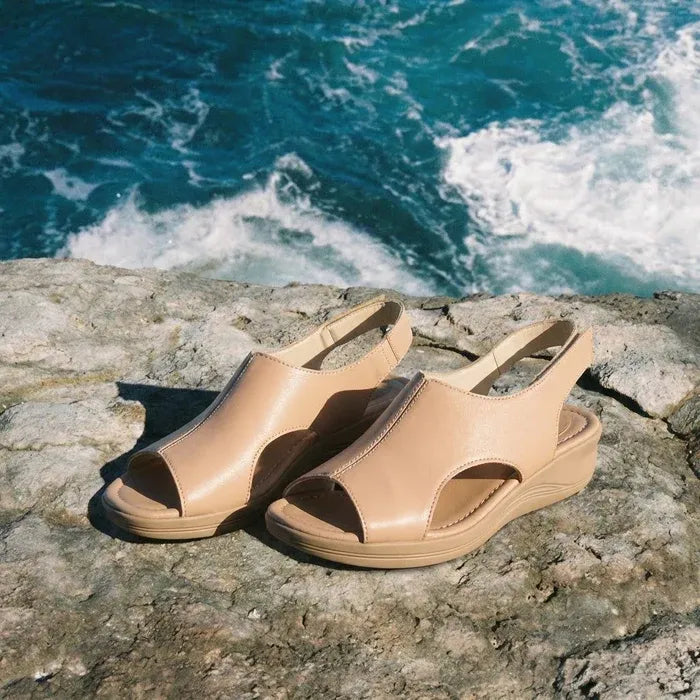 Par de sandálias ortopédicas femininas nude em cenário de verão